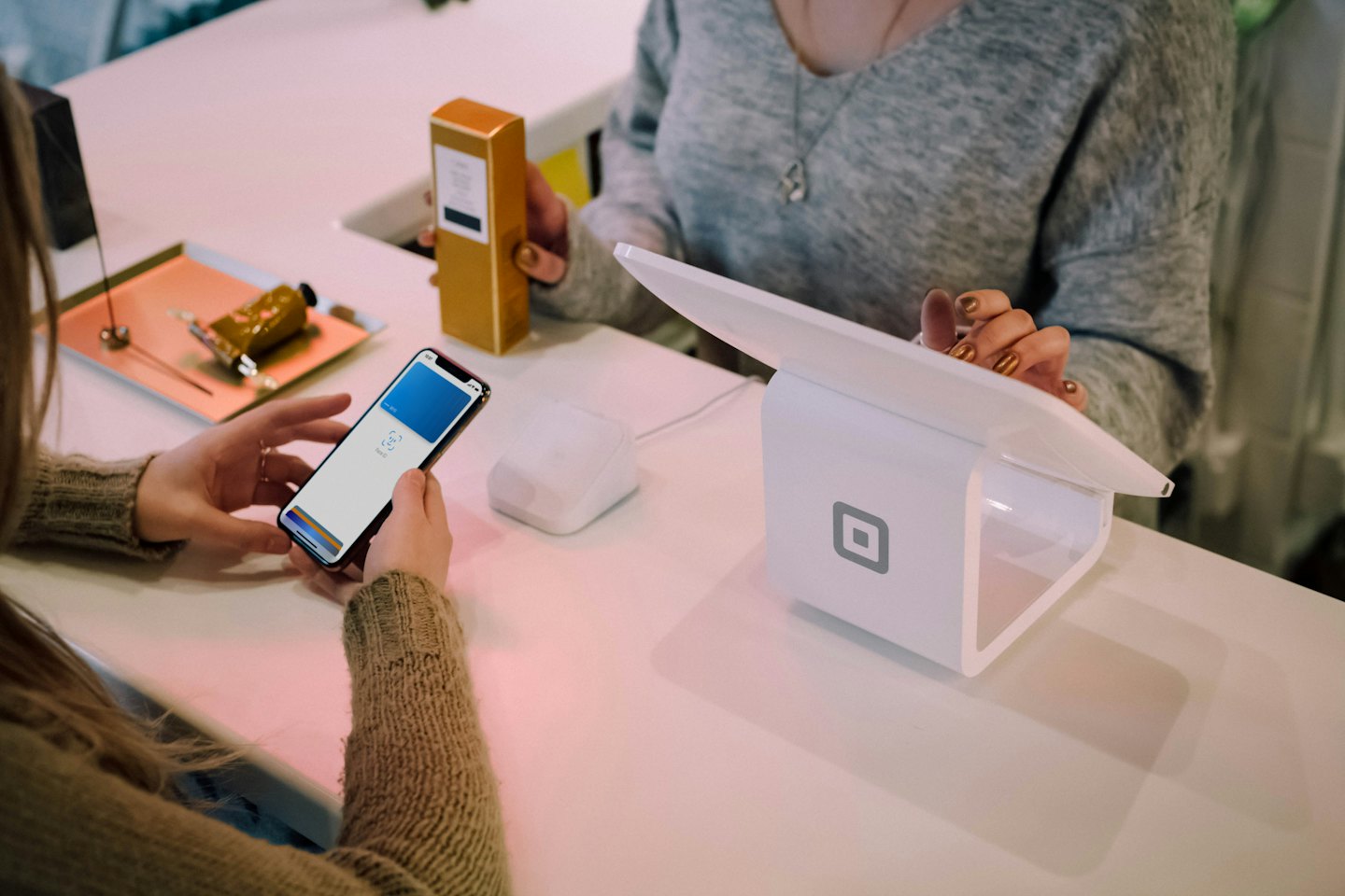 Customer paying with smartphone at retail counter with product.